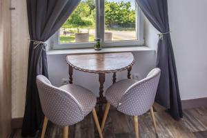 a table and two chairs in front of a window at Chambre d'hotes 2 à Bramefort in Champsac +11 photos