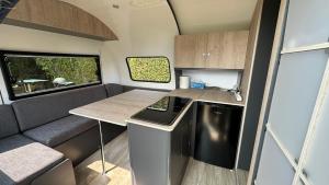 an rv kitchen with a counter and a table at La caravane de Camille & Piscine in Soulaires