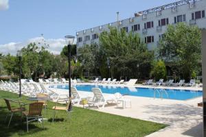 a swimming pool with chairs and a building at Grand Erdek Hotel in Erdek