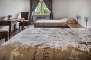 a bedroom with two beds and a desk and a window at Chambre d'hotes 3 et 4 a la ferme in Champsac