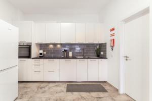 a kitchen with white cabinets and a sink at Casa Formosa in Odeceixe