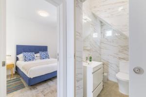 a bedroom with a blue bed and a bathroom at Casa Formosa in Odeceixe +18 photos