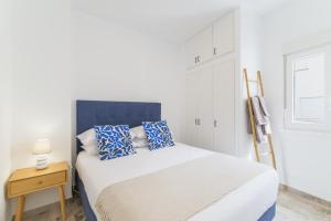 a bedroom with a large bed with blue pillows at Casa Formosa in Odeceixe