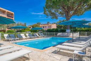 a swimming pool with lounge chairs and umbrellas at Eden Azur - Résidence Hôtelière in Golfe-Juan