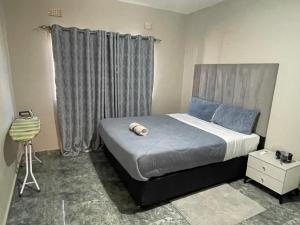 a bedroom with a large bed with blue pillows at Cadami apartments in Mazabuka +6 photos