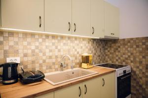 a kitchen with white cabinets and a sink at Emporios 1930, Seafront stone house in Emporeiós +43 photos