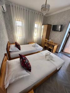a hotel room with two beds and a table at LAYALI boutique TERRACE & Café in Bukhara