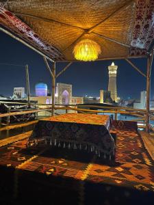 a bed on a roof with a view of a city at LAYALI boutique TERRACE & Café in Bukhara