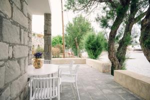 a white table and chairs on a patio at Emporios 1930, Seafront stone house in Emporeiós