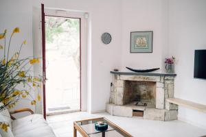 a living room with a fireplace and a window at Emporios 1930, Seafront stone house in Emporeiós