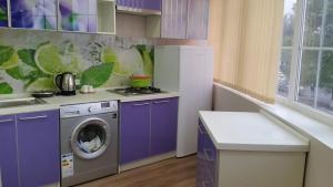 a kitchen with purple cabinets and a washing machine at Apart Hotel 12 in Khujand