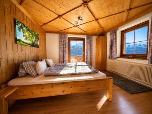 a bedroom with a bed in a wooden room at Hochleiten-Gut in Niedernsill