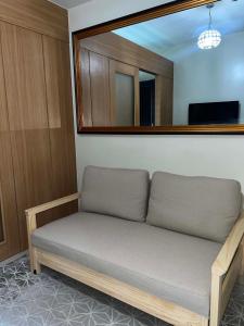 a couch sitting in a room with a mirror at Shell Residences in Sampong