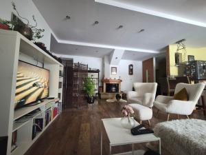 a living room with a flat screen tv and a couch at Butas Karklėje in Karklė