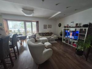 a living room with a couch and a tv at Butas Karklėje in Karklė