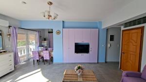 a living room with a tv and purple walls at Mary's Apartment - Close to port, beaches in Kos