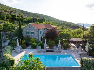 a house with a swimming pool in front of a house at Villa Stari Mlin in Luštica