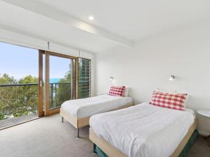 two beds in a room with a large window at Wye View in Wye River