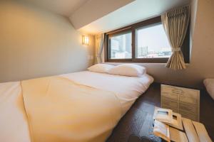 a small bedroom with a bed and a window at Seoul101 Jongno in Seoul