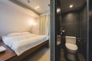 a small bedroom with a bed and a toilet at Seoul101 Jongno in Seoul