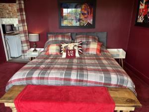 a bedroom with a bed with a red wall at The Flat The Plough in Birdbrook