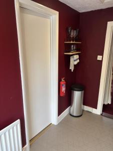 a room with a door and a trash can at The Flat The Plough in Birdbrook