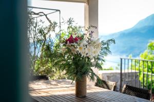 a vase filled with flowers sitting on a table at Villa Stari Mlin in Luštica