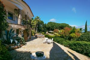 a patio of a house with chairs and a fountain at Villa Maravilla in Lloret de Mar