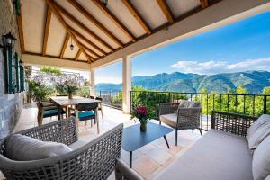 a patio with a table and chairs and a view of mountains at Villa Stari Mlin in Luštica