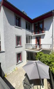 a white building with an umbrella in front of it at Gîte de l 'Annonciation in Lourdes