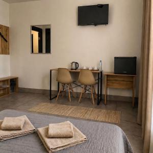a room with a table and chairs and a television at Mia Hotel in Rivne