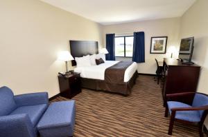 a hotel room with a bed and a desk and a couch at Cobblestone Inn & Suites - Manning in Manning