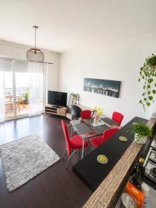 a living room with red chairs and a table at Vista dall' Eden in Mortola Superiore