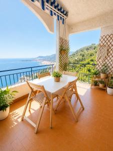 a table and chairs on a balcony with a view of the ocean at Vista dall' Eden in Mortola Superiore
