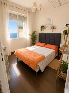 a bedroom with a large bed with an orange blanket at Vista dall' Eden in Mortola Superiore