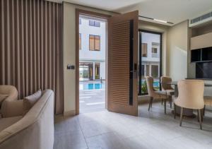 a living room with a sliding door with a table and chairs at Aswar Hotel in Al Khobar