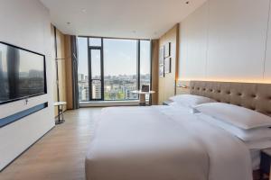 a hotel room with two beds and a large window at Four Points by Sheraton Linyi Hedong in Linyi +20 photos