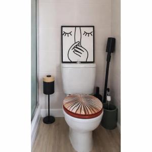 a bathroom with a toilet with a picture on the wall at le Cosy - Studio Apparthotel in Saint-Denis