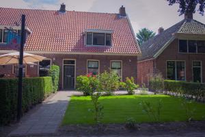 una casa con un patio verde con una casa en Brink 3 Diever, en Diever