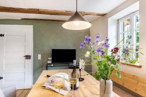 a room with a table with a bottle of wine and flowers at Ferienhaus Gerbertor am Goldbach in Dörzbach