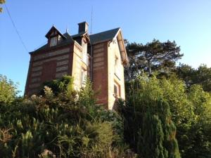 an old brick building on top of a hill at La Maison de la Rose in Étretat
