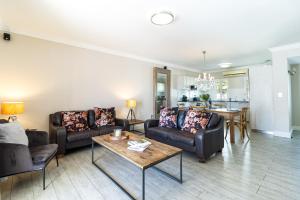 a living room with couches and a table at Winelands Golf Lodges 24 in Stellenbosch +52 photos