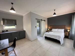 a bedroom with a bed and a table and chairs at ValView Guest Lodge in Thabazimbi