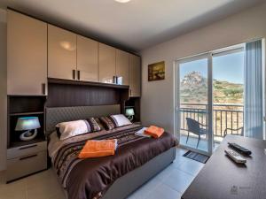 una camera da letto con un letto e un balcone di Hillock Residence Apartments a Marsalforn