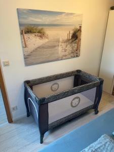 a dresser in a bedroom with a painting on the wall at Rosenhaus Esens - Wohnung Backbord in Esens