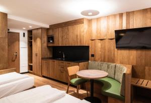 a room with a bed and a table and a tv at Residence Antares in Selva di Val Gardena