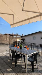 a picnic table with oranges on it under an umbrella at Casa Sophie in Consiglio di Rumo