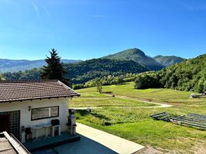 a house with a view of a field and mountains at Agriturismo La Falesia in Bagnasco +6 photos