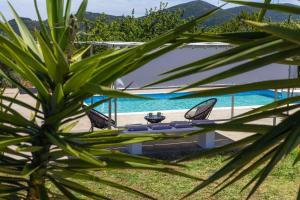 a table and chairs on a beach near the water at Vainas Belvedere Villa in Skopelos Town