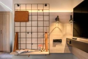 a room with a table and a wall with lights at Moxy Dresden Neustadt in Dresden